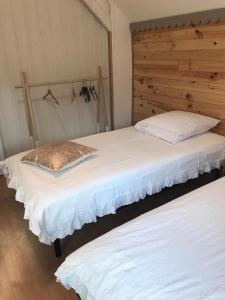 two beds in a bedroom with a wooden headboard at Chalet Sérénité in Moux-en-Morvan