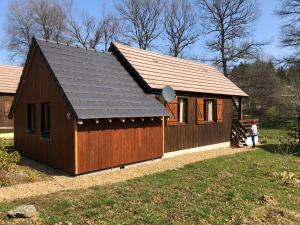a large wooden building with a gambrel roof at Chalet Sérénité in Moux-en-Morvan
