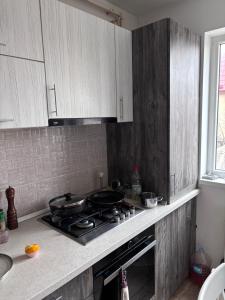 a kitchen with white cabinets and a stove top oven at Angels Home Apartment in Bucharest