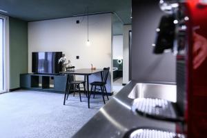una cucina e una sala da pranzo con tavolo e sedie di BRIX - Self Check-In Hotel a Risch-Rotkreuz