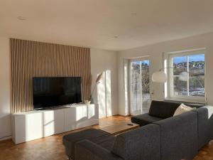 a living room with a couch and a flat screen tv at Gästewohnung mit Schlossblick in Weikersheim