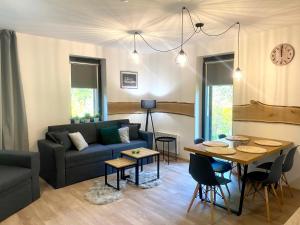 een woonkamer met een bank en een tafel bij Apartmán Mlýn Herlíkovice 205 in Vrchlabí