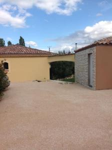 MontégutにあるGers habitationの車道の隣にガレージがある建物