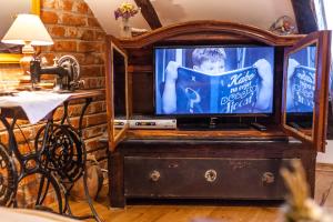 a television sitting on a dresser with a child on the screen at Country House "Stričev grunt" Stara Kapela in Stara Kapela