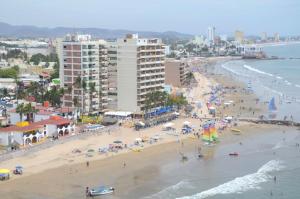 vistas a una playa con personas y edificios en Las Flores Beach Resort en Mazatlán