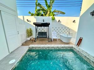 a bathroom with a swimming pool and a tub and a sink at Laticha casa in Bangsaen