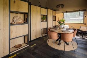 a room with a table and chairs in a trailer at Crossover lodge de la vallée in Durbuy +21 photos