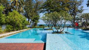 a swimming pool with blue water and trees at Baan Sandao Condo Hua Hin in Hua Hin