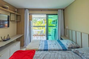 a bedroom with two beds and a balcony at Rooftop Tamandaré - apto 106 in Tamandaré