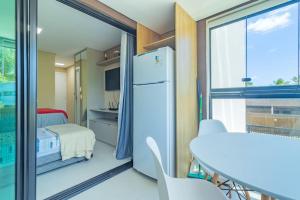 a small room with a refrigerator and a bedroom at Rooftop Tamandaré - apto 106 in Tamandaré