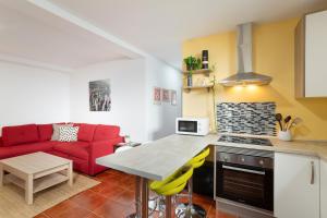 a kitchen and living room with a red couch at Casa Alejandro in Firgas
