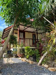 a house with a balcony and a bunch of plants at Blue Sky Bungalow in Ko Jum