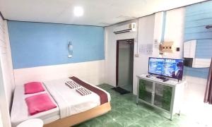 a hospital room with a bed and a flat screen tv at Best House Resort in Ban Pak Ba Ra