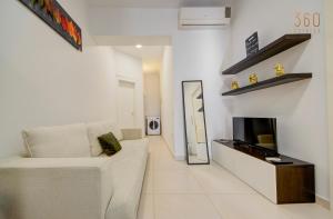 a living room with a white couch and a tv at Cozy Studio home with Stunning Mosta Dome Views by 360 Estates in Mosta