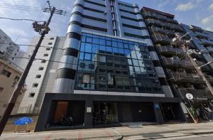 een hoog gebouw met veel ramen bij 大国町駅徒歩3分 なんば駅1駅 最大4名 ロイヤル507 in Osaka