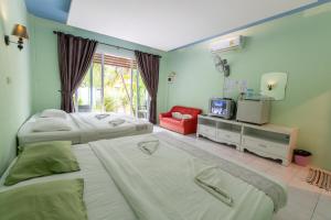 sypialnia z dwoma łóżkami i telewizorem w obiekcie Best House Resort w mieście Ban Pak Ba Ra