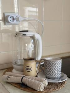 een aanrecht met een koffiepot, kopjes en handdoeken bij Savina apartment Herceg Novi in Herceg-Novi