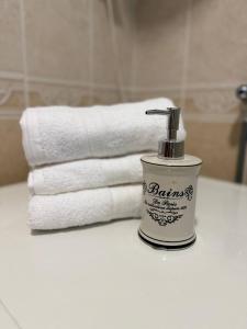 een stapel handdoeken en een zeepdispenser op een aanrecht bij Savina apartment Herceg Novi in Herceg-Novi