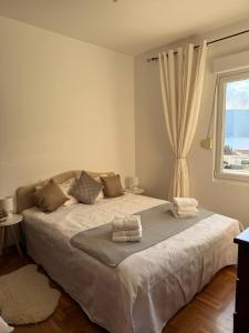 een slaapkamer met een groot bed met een raam bij Savina apartment Herceg Novi in Herceg-Novi +23 foto's