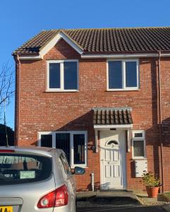 a red brick house with a white door at Montrose House in Swindon