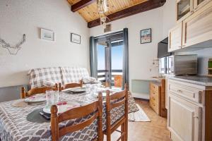 a kitchen and dining room with a table and a microwave at La Singlantane - Duplex vue montagne aux Angles in Les Angles