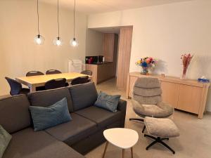 a living room with a couch and a table at Ruytingen Modern Seaside Suite in Koksijde