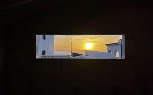 a view of a sunset from a window of a building at 1 minute from beach - Baleal Wood Cabin in Baleal