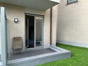 Un patio con una silla al costado de un edificio. en Ruytingen GV01, en Koksijde