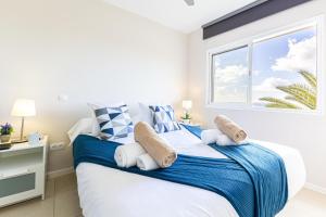 a bedroom with a bed with blue and white pillows at Nueva S 523 by VillaGranCanaria in San Agustin