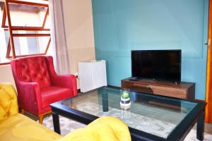 a living room with two red chairs and a tv at The Pearl in Harties Dam in Hartbeespoort