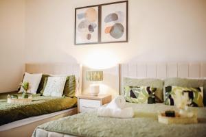 ein Schlafzimmer mit zwei Betten und einem Tisch mit Lampe in der Unterkunft Modern Central Luxury Home with Hot Tub Sauna 12PPL in Sheffield