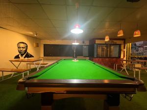 a man standing in a room with a pool table at Chautara Restro & Inn in Kathmandu