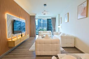 un soggiorno con mobili bianchi e TV a schermo piatto di Burj Vista 2BR Luxurious Apartment with Direct Access to Dubai Mall a Dubai