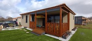 a small house with a large deck on a yard at Charmant Cottage in Saubrigues