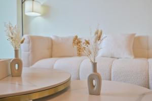 un soggiorno con divano e 2 vasi su un tavolo di Burj Vista 2BR Luxurious Apartment with Direct Access to Dubai Mall a Dubai
