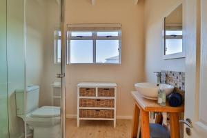 ベティーズ・ベイにあるTidesの洗面台、トイレ、鏡のあるバスルーム