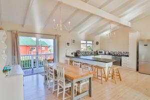 ベティーズ・ベイにあるTidesのテーブルと椅子と冷蔵庫のあるキッチン