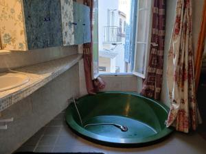 een badkamer met een groen bad en een raam bij Loft Americain Centre-Ville in Marseille +32 foto's