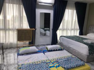 a bedroom with two beds and pillows on the floor at MKB Homestay - 2 X King Bed Studio Room with view & FREE parking in Shah Alam