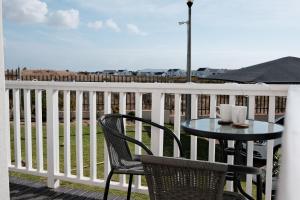 ランゲバーンにあるLuxury Sunset Heights Unit 79の眺めの良いバルコニーにテーブルと椅子が置かれている