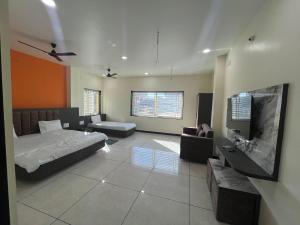 a bedroom with a bed and a flat screen tv at Yashomati Hotel in Maheshwar