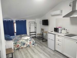 a small room with a bed and a kitchen at La Vía Verde in Jérica