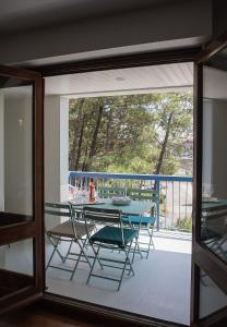 a table and chairs on a balcony with a glass window at Rameau in Hossegor +3 photos