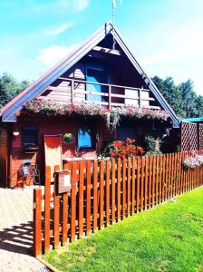 a house with a fence in front of it at Marianówka in Wilcze