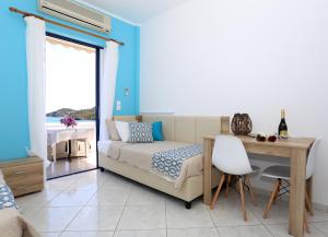 a bedroom with a bed and a desk and a table at Yiannis Studios in Agia Marina Aegina