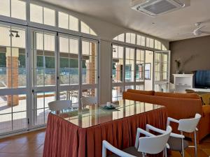 une pièce avec une table, des chaises et des fenêtres dans l'établissement El Bosque del Duende - Ole Solutions, à Arcos de la Frontera