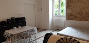 a living room with a table and a window at Studio 2 - 3 minutes du Futuroscope in Chasseneuil-du-Poitou
