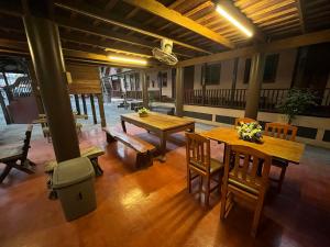 a room with wooden tables and chairs in a building at Old City Guest House in Sukhothai +19 photos