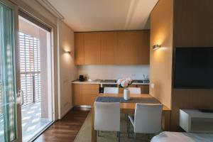 een keuken met een tafel met stoelen en een televisie bij Giax Panoramic View Parking in Milaan