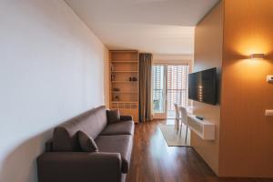 een woonkamer met een bank en een tv bij Giax Panoramic View Parking in Milaan